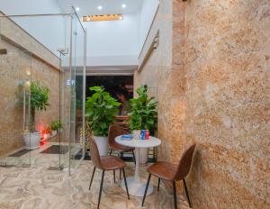 a room with a table and chairs and plants at Uy Dương Hotel & Apartment - Nha Trang in Nha Trang