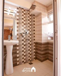 a bathroom with a sink and a shower at Nhoo: Chhen Apartment by Casa Deyra in Pātan