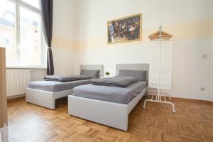 2 Betten in einem Zimmer mit Holzböden in der Unterkunft FULL HOUSE Premium Apartments - Halle Paulusviertel in Halle an der Saale