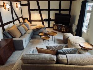 sala de estar con sofá, mesas y TV en Holiday House BURGBLICK1 with terrace - VOSPROPERTIES en Monschau