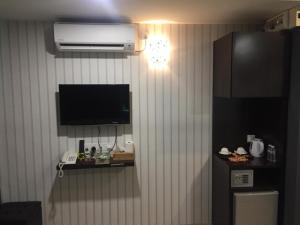 7 Hotel في Juru: غرفة بجدار فيها تلفزيون وثلاجة
