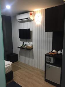 Kleines Zimmer mit einer Küche und einem TV. in der Unterkunft 7 Hotel in Juru
