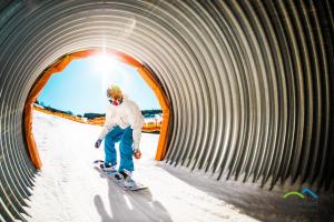 a man riding a snowboard through a tunnel at Horský hotel Žižkova bouda in Pec pod Sněžkou