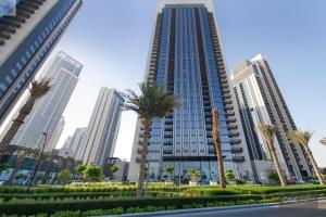 a tall building with palm trees in front of it at High Floor - Stunning Location - Canal View in Dubai