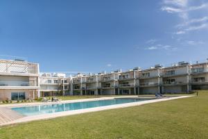 ein Apartmenthaus mit einem Pool davor in der Unterkunft Oitava Maravilha in Nazaré