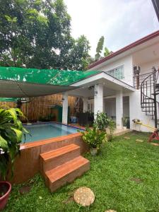 un patio trasero con piscina y una casa en Buddy's Escape - Tagaytay, en Upli