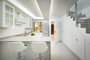 een keuken met witte werkbladen en witte krukken bij Villacana 2907 in Estepona