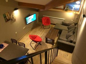 a living room with red chairs and a couch at Two various entire apartments in New Gudauri -Redco, Near Main Gondola in Gudauri