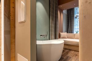 特倫托的住宿－Calepina Alpine Suite，一间带白色浴缸和床的浴室