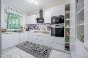 uma cozinha branca com armários brancos e uma janela em Private House em Hanôver