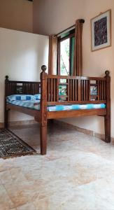 a large wooden bed in a room with a window at Bageecha B&B- Vaayu in Alibaug
