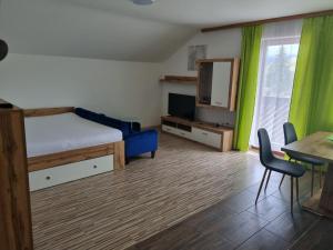 a bedroom with a bed and a tv and a table at Appartementhotel Rutar Lido in Eberndorf