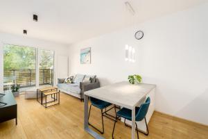 a kitchen and living room with a table and chairs at Apartament SAND SurfingBird Dźwirzyno in Dźwirzyno