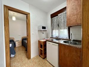 a small kitchen with a sink and a microwave at Cozy apartment, FreeWifi, nearby beach in Cadavedo in Cadavedo