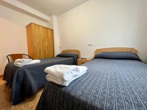 two beds in a room with towels on them at Cozy apartment, FreeWifi, nearby beach in Cadavedo in Cadavedo