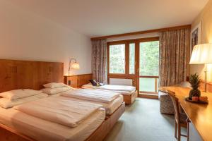 a hotel room with two beds and a window at Hotel Restaurant Südrast Dreiländereck in Arnoldstein