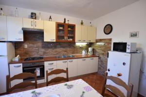 a kitchen with white cabinets and a white refrigerator at Apartment Marin in Primošten