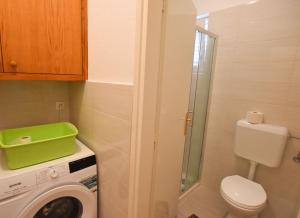 a bathroom with a toilet and a washing machine at Apartment Marin in Primošten