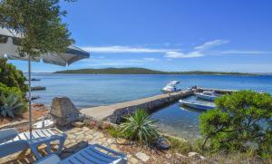 a couple of blue chairs and a boat in the water at House Vagabond in Tkon +16 photos