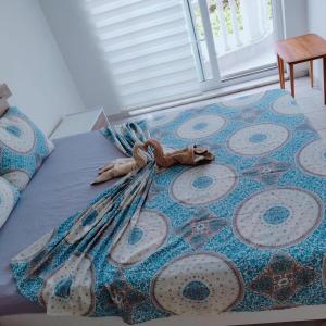 a bed with a blue blanket with a bow on it at Belka Golf Residence Exclusive Apt Poolside in Belek