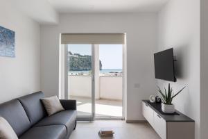 a living room with a couch and a tv at Oneweek Gaeta Suites and Apartments in Gaeta