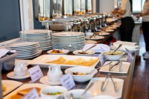 a buffet line with plates and bowls of food at Amina Residency in Male City