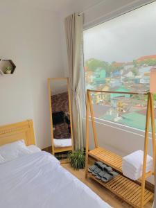 a bedroom with a bed and a mirror and a window at Mi Casa Homestay in Da Lat