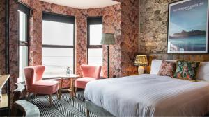Avoca Hotel في نيوكاسل: غرفه فندقيه بسرير وكرسيين