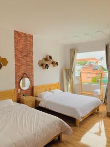 - une chambre avec 2 lits et une fenêtre dans l'établissement Mi Casa Homestay, à Đà Lạt