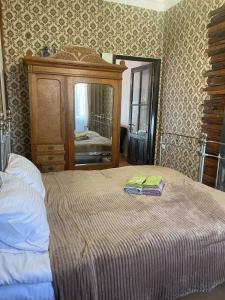 a bedroom with a bed with a dresser and a mirror at Silve Apartment in Tbilisi City