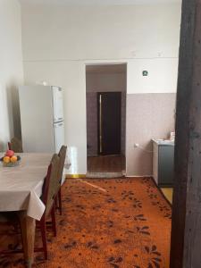 uma cozinha com uma mesa e um frigorífico num quarto em Silve Apartment em Tbilisi