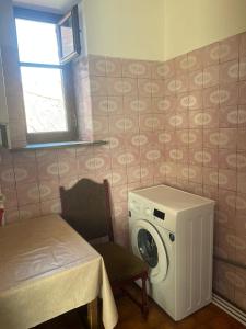 a washing machine in a room with a table and a window at Silve Apartment in Tbilisi City