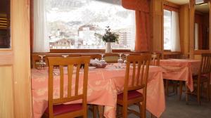 una sala da pranzo con tavolo e tovaglia rosa di Hotel Breuil a Breuil-Cervinia