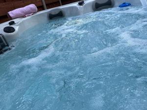 a large pool of blue water in a bath tub at Holly Cabin with Hot Tub in York