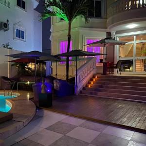un hall avec des escaliers et des parasols dans un bâtiment dans l'établissement L'Address Bar-Piscine-Restaurant, à Cotonou