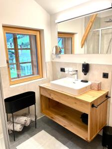 a bathroom with a white sink and a mirror at Appartements Zur Post in Gries im Sellrain