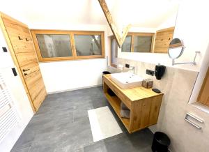 y baño con lavabo y armarios de madera. en Appartements Zur Post, en Gries im Sellrain