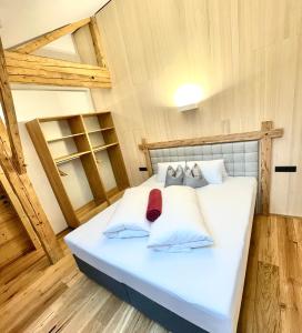 a large white bed in a room with wooden floors at Appartements Zur Post in Gries im Sellrain