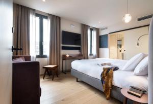 アヌシーにあるHébé Hotelの大きなベッドとソファが備わるホテルルームです。