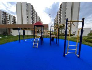 une aire de jeux avec un sol bleu et une balançoire dans l'établissement Apartamento en conjunto hacienda Peñaliza Limonar, à Ricaurte