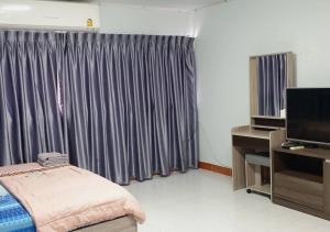 a room with a bed and a tv and a window at ห้องใหญ่-ห้องพักรายวัน เมืองทองธานี เรือนศรีตรัง in Nonthaburi