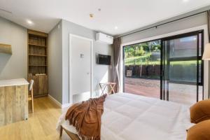 una camera con un grande letto e una porta scorrevole in vetro di Echo Lodge ad Auckland