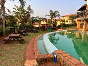 a pool at a resort with a picnic table and picnic tables at Ocean View Villas: Port Edward Unit H09 in Port Edward