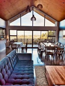a living room with a couch and tables and windows at Echo Lodge in Auckland