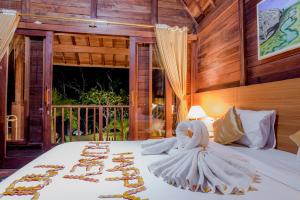 una habitación con una cama con un montón de favores de oro en The Granyam Garden Cottage, en Nusa Penida