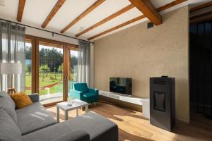 ein Wohnzimmer mit einem Sofa und einem TV in der Unterkunft Moje Miejsce Jura in Lgota Murowana