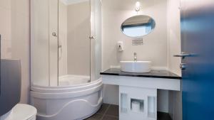 a white bathroom with a sink and a shower at HERMITAGE by Elenis in Sfântu-Gheorghe +24 photos