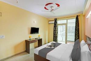 een hotelkamer met een bed en een televisie bij Hotel Ashvins Palace in Gurgaon