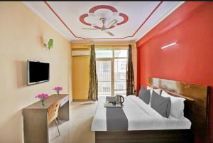 een rode kamer met een bed en een televisie bij Hotel Ashvins Palace in Gurgaon