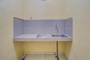 a kitchen with a sink and purple tiles at OYO 91738 Ciung Wanara Guest House in Denpasar
